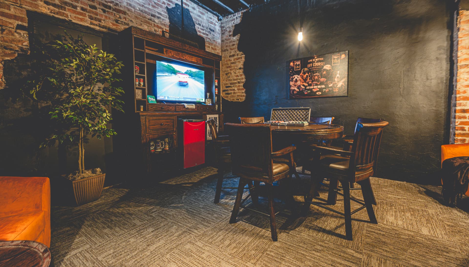 Off Course private Speakeasy with brick walls, leather seating, TV and card table