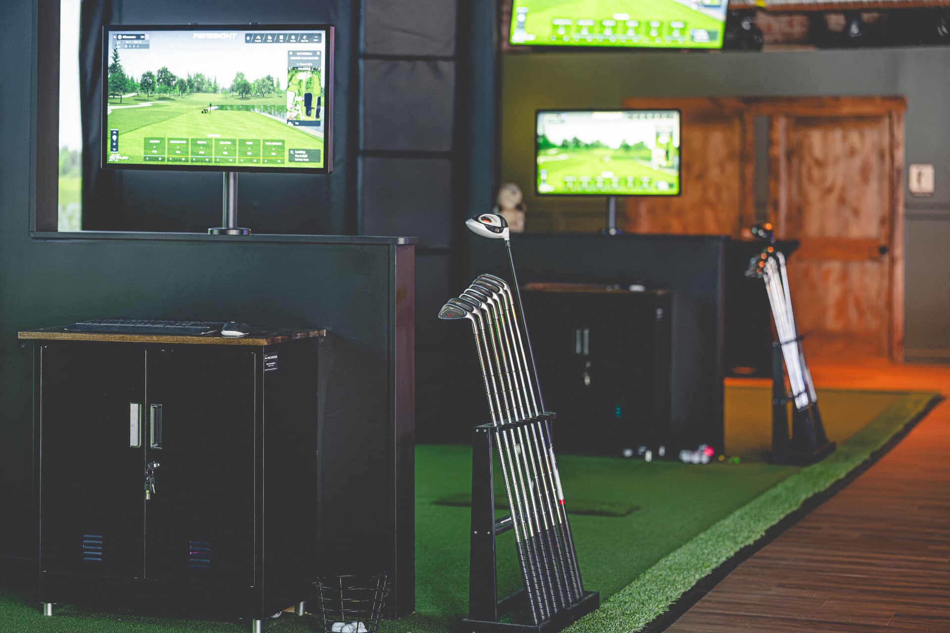 Off Course simulator bays with clubs, Foresight monitors and large screens
