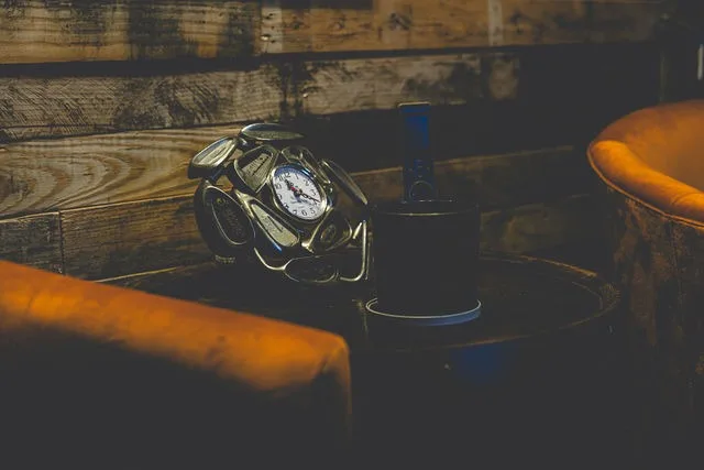 A golf-club clock on a side table between lounge chairs