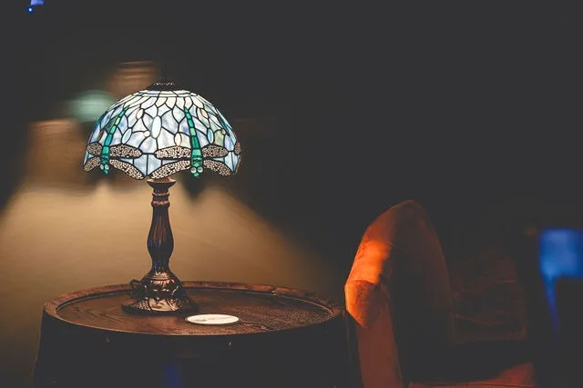 A stained-glass lamp beside an orange velvet chair
