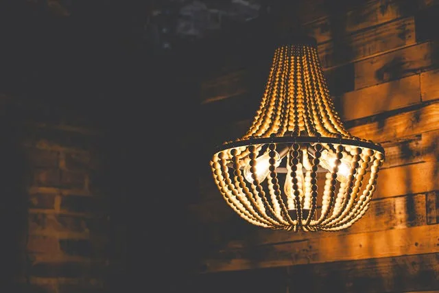 A beaded chandelier against a reclaimed wood wall