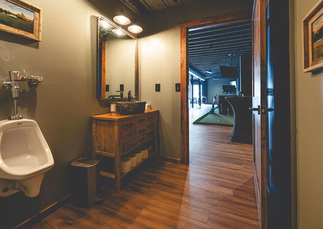 A restroom with a wood vanity, looking out to the bays